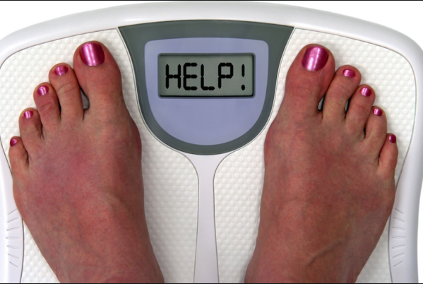 A person on a digital scale weighing themself.